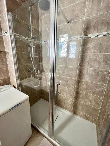 une douche avec une porte vitrée dans une salle de bain dans l'établissement Bel appartement avec balcon en centre-ville, à Nice