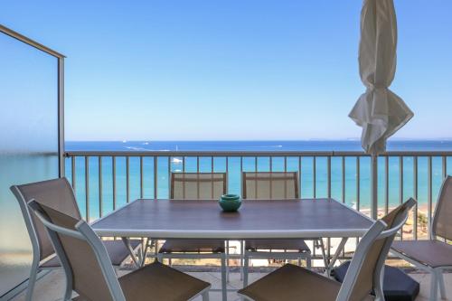 une table et des chaises sur un balcon avec l'océan dans l'établissement Bord de plage - Studio en front de mer, au Lavandou