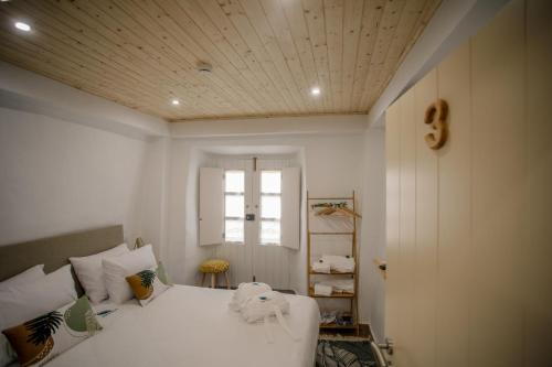 a bedroom with a white bed and a window at Óbidos Pátio House in Óbidos