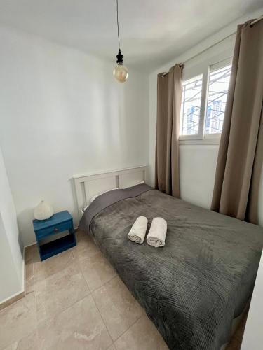 - une chambre avec un lit et 2 chaussons blancs dans l'établissement Bel appartement avec balcon en centre-ville, à Nice