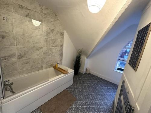 a bathroom with a bath tub and a window at Spectacular 2 bedroom on Tower Bridge in London