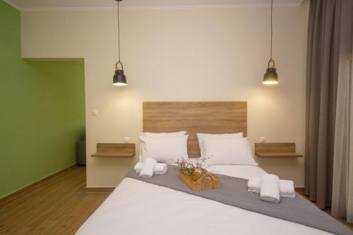 - une chambre avec un grand lit blanc et deux lumières dans l'établissement Arismari House, à Ravdhoúkha