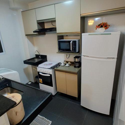 een kleine keuken met een koelkast en een magnetron bij Apto Executivo Ravena II in Campo Grande