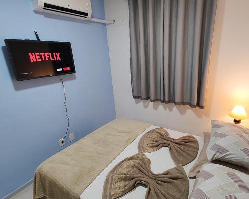 een kamer met een bed en een tv aan de muur bij Apto Executivo Ravena II in Campo Grande