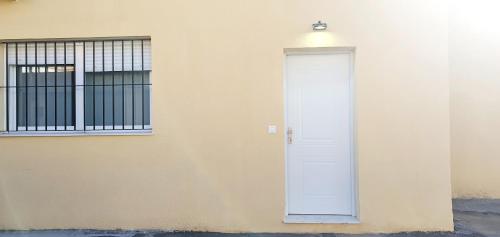 a white door on the side of a building at Apartamento Plaza Calzada 3 in Sanlúcar de Barrameda