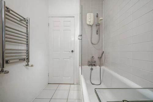 a white bathroom with a tub and a shower at Spacious Apartment in Jesmond with Parking in Jesmond