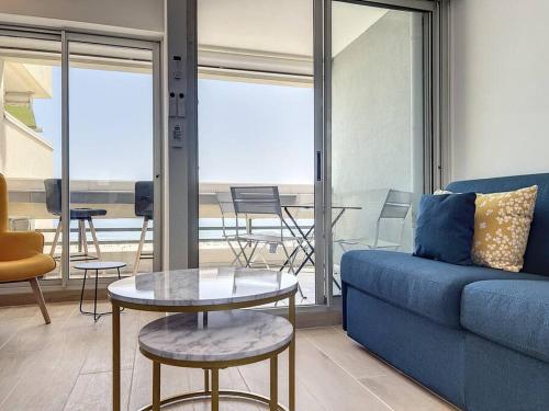 un salon avec un canapé bleu et une table dans l'établissement Appartement T2 cabine vue mer, à Canet