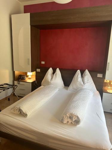 a bedroom with a large white bed with a red headboard at Villa Ginevra Resort Agrituristico in Ficarra