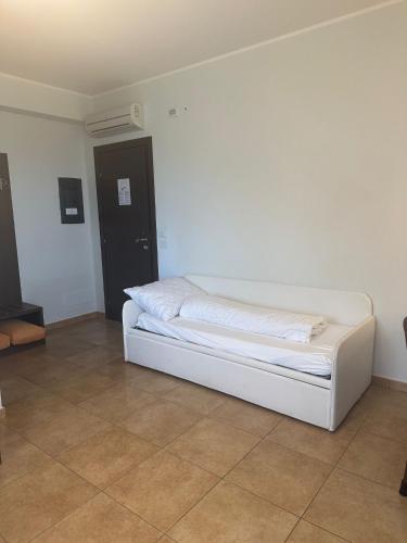 a white bed sitting in a room with a tiled floor at Villa Ginevra Resort Agrituristico in Ficarra