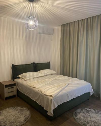 a bedroom with a bed and a chandelier at Casa Gazi in Ulcinj