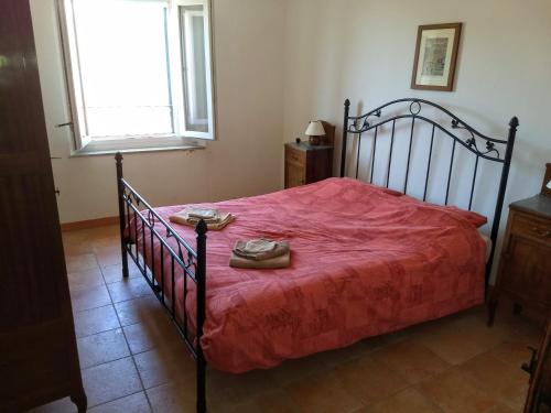 Un dormitorio con una cama con sábanas rojas y zapatos. en Casa nell'arco, en Bagni di Lucca