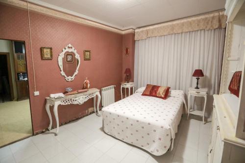 a bedroom with a bed and a vanity and a mirror at Casa Auela Maria in Bocairent