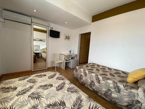 a bedroom with a bed and a desk with a table at Hotel Playa in Peñíscola