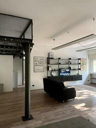 a living room with a black couch in a room at Stylish Loft in Milan Mi-CoFiera-CityLife in Milan