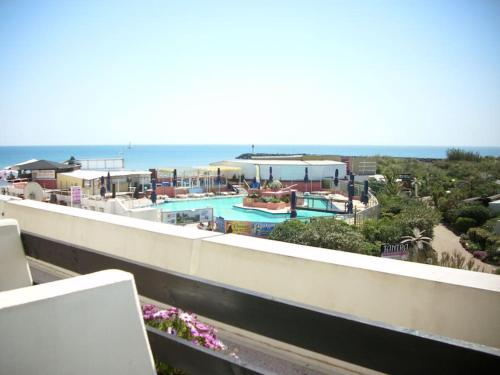 une vue sur une piscine et l'océan dans l'établissement Studio 74, Port Nature 2 au village naturiste, au Cap d'Agde
