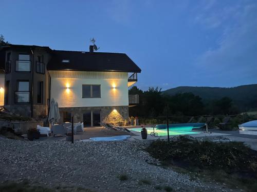 a villa with a swimming pool at night at Apartamenty 'Okno z widokiem' in Wisła