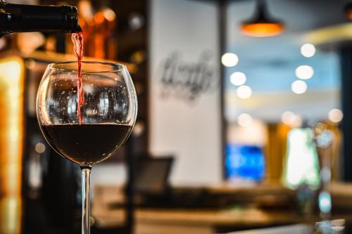 a glass of red wine being poured into it at Dorana Hotel in Kérynia