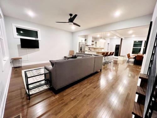 a living room with a large couch and a kitchen at Riverside House in Asheville