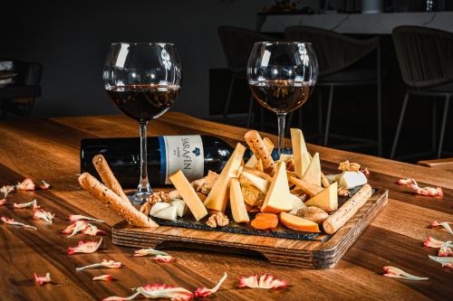 a tray of cheese and wine glasses on a table at Dorana Hotel in Kérynia