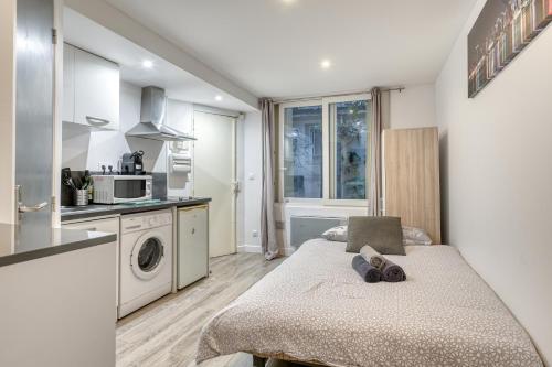 Ce petit appartement comprend une cuisine et un lit. dans l'établissement Studio moderne 2 personnes près de la Bastille, à Paris