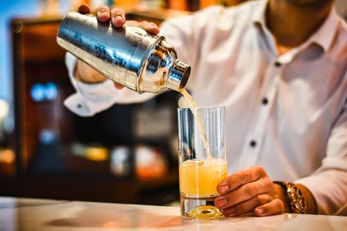 a bartender pouring a drink into a glass at Dorana Hotel in Kérynia