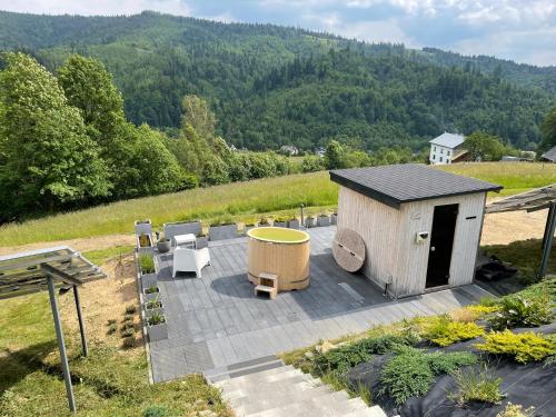 a building with a hot tub and a table and chairs at Apartamenty 'Okno z widokiem' in Wisła