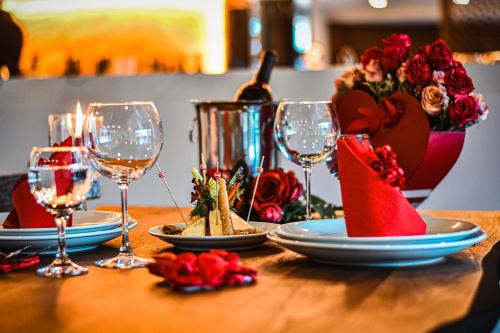 a table with wine glasses and plates of food and flowers at Dorana Hotel in Kérynia