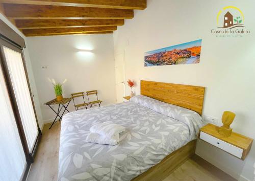 - une chambre avec un grand lit et une tête de lit en bois dans l'établissement Casa de la Galera Alojamiento Turístico en Toledo, à Tolède