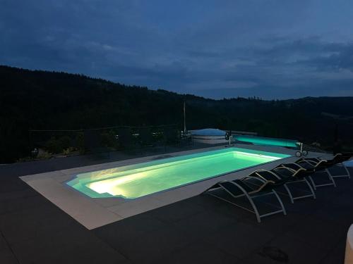 a swimming pool with four chairs at Apartamenty 'Okno z widokiem' in Wisła