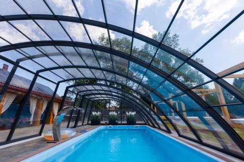an indoor swimming pool with a glass tunnel and a swimming pool at Agroturystyka Kalinka in Wiżajny