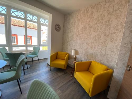 a waiting room with yellow chairs and a table at HOSPEDAJE STOP in Corrubedo