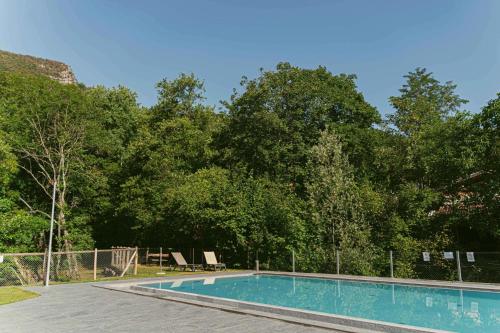 米瑞德的住宿－Ca Stella Camping del Monte San Giorgio，一座树木繁茂的庭院内的游泳池