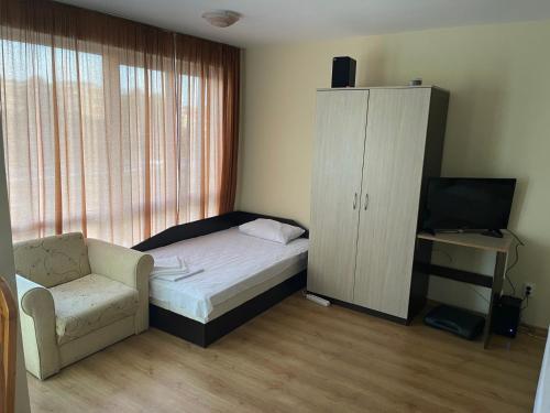 a bedroom with a bed and a chair and a cabinet at Viva Apartment in Sunny Beach