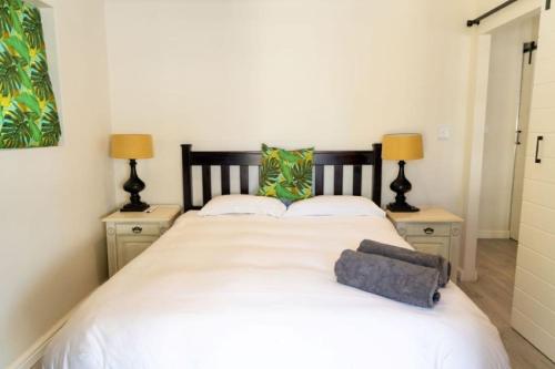 a bedroom with a large white bed with two lamps at Mitre's Edge Orchard Suite in Klapmuts