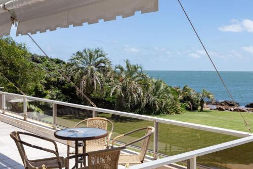 balcón con mesa, sillas y vistas al océano en Oceana Suites en Acantilados, vista al mar, en Punta del Este