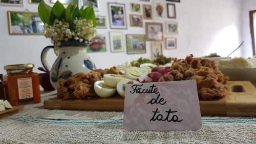 una mesa con un plato de comida con un cartel en Andrada's House Soars, en Şoarş