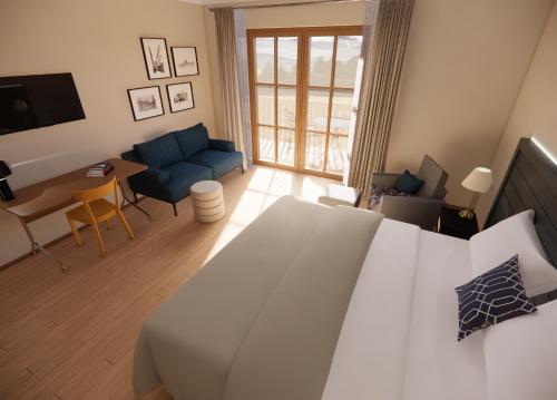 ein Schlafzimmer mit einem weißen Bett und ein Wohnzimmer in der Unterkunft HENRI Country House Kitzbühel in Kitzbühel