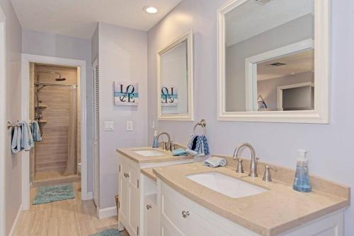 a bathroom with two sinks and two mirrors at Family friendly with large pool in Sarasota