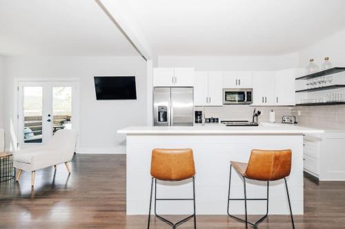 Una cocina blanca con sillas naranjas y una encimera. en Sage House, en Asheville