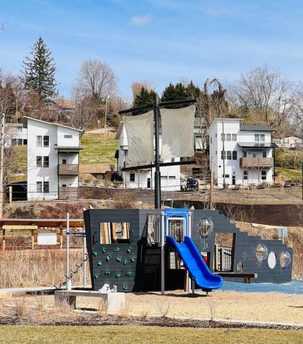 a playground with a blue slide in front of houses at Sage House in Asheville