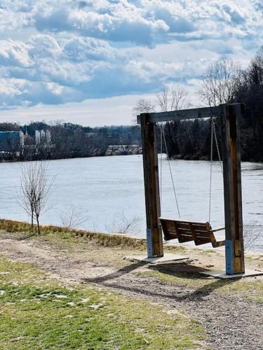 an empty swing seat next to a body of water at Sage House in Asheville