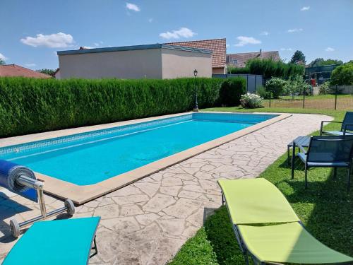 une piscine avec deux chaises longues et une piscine dans l'établissement L'Argentique, à Ceffonds