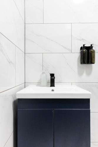 a bathroom with a blue cabinet and a sink at Chic Urban 2 Bedroom Apartments in Cardiff