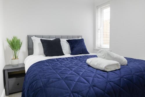 Chic Urban 2 Bedroom Apartments في كارديف: سرير مع لحاف أزرق في غرفة النوم