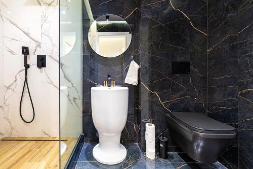 a bathroom with a toilet and a glass shower at Style and luxury 10mins Center in Plovdiv
