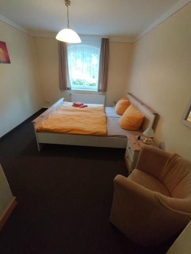 1 dormitorio con 1 cama, 1 silla y 1 ventana en Ferienwohnung 3 Am Zahnsborn en Bad Schandau