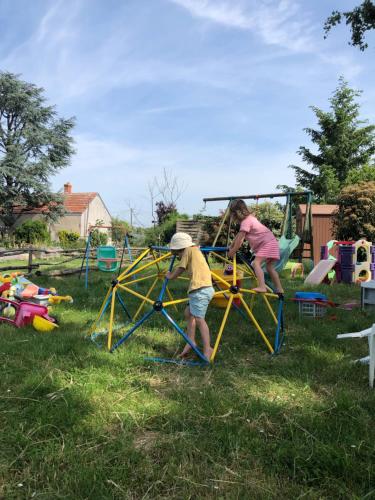 two children playing on a playground in a yard at Chambre d'Hôtes chez Gustave & Compagnie in Choussy