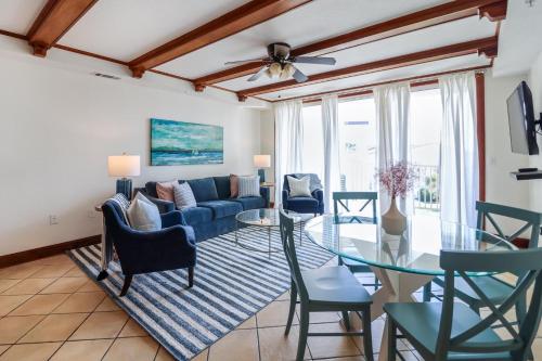 a living room with a blue couch and a glass table at The Vue 233 in Tybee Island
