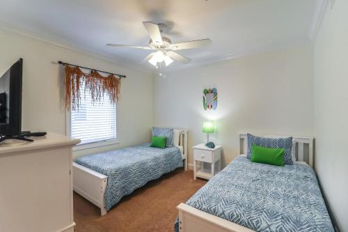 - une chambre avec 2 lits et un ventilateur de plafond dans l'établissement Sea Sight Villa B, à Tybee Island