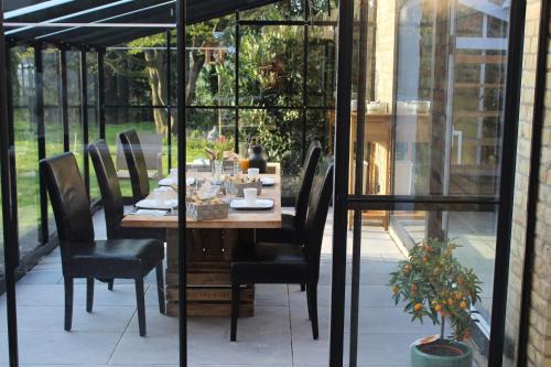 a wooden table and chairs on a patio at B&B L’Orangerie in Lo-Reninge